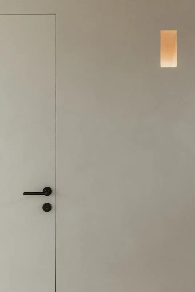 Onzichtbare deur in microcement met verlichte inkijknis, where architecture creates space for experience, interieur Laura Calleeuw
