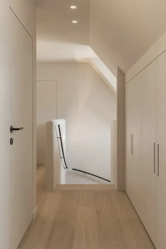 Overloop met kastenwand onder het schuine dak en eikenhouten vloer, where architecture creates space for experience, interieur Laura Calleeuw