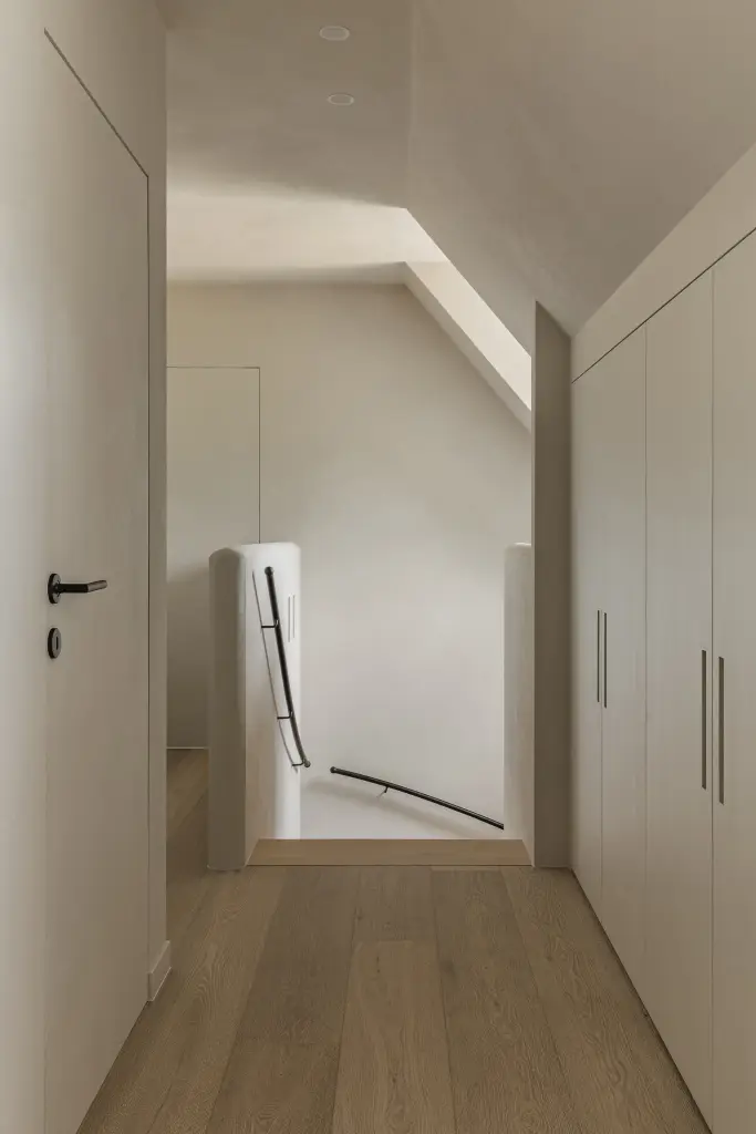 Overloop met kastenwand onder het schuine dak en eikenhouten vloer, where architecture creates space for experience, interieur Laura Calleeuw
