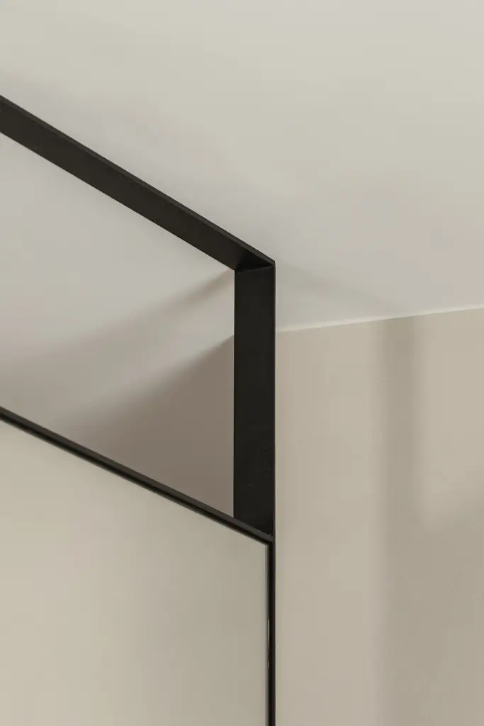 Hoek van een zwart stalen kader met glas, where architecture creates space for experience, interieur Laura Calleeuw