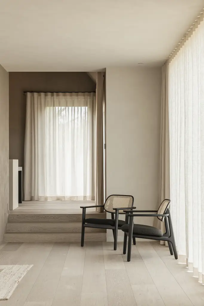 Zithoek met twee rotan fauteuils op een verhoogd podium voor het raam, where architecture creates space for experience, interieur Laura Calleeuw
