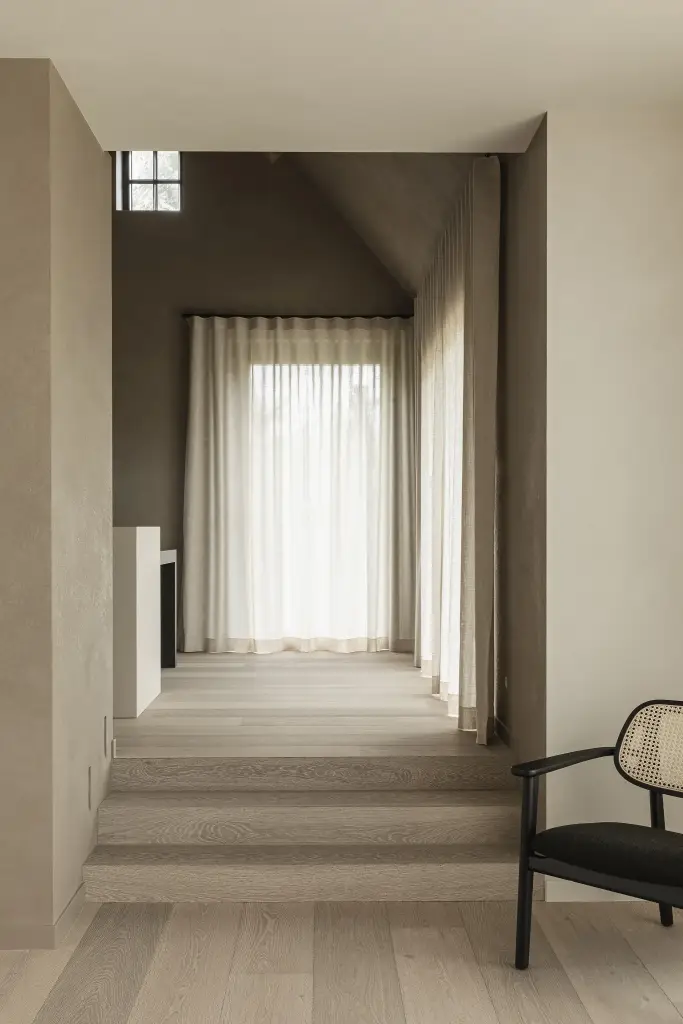 Zithoek met twee rotan fauteuils op een verhoogd podium voor het raam, where architecture creates space for experience, interieur Laura Calleeuw
