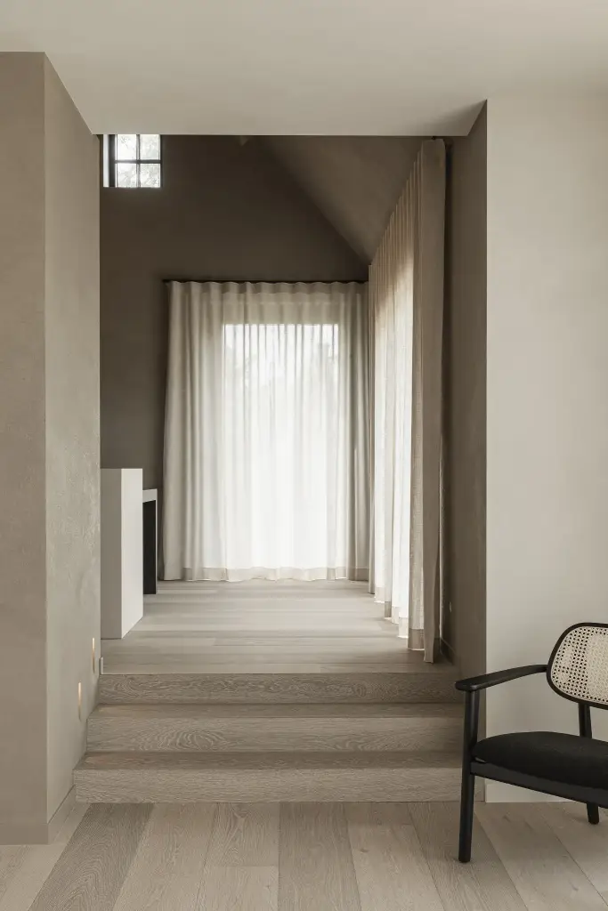 Zithoek met twee rotan fauteuils op een verhoogd podium voor het raam, where architecture creates space for experience, interieur Laura Calleeuw