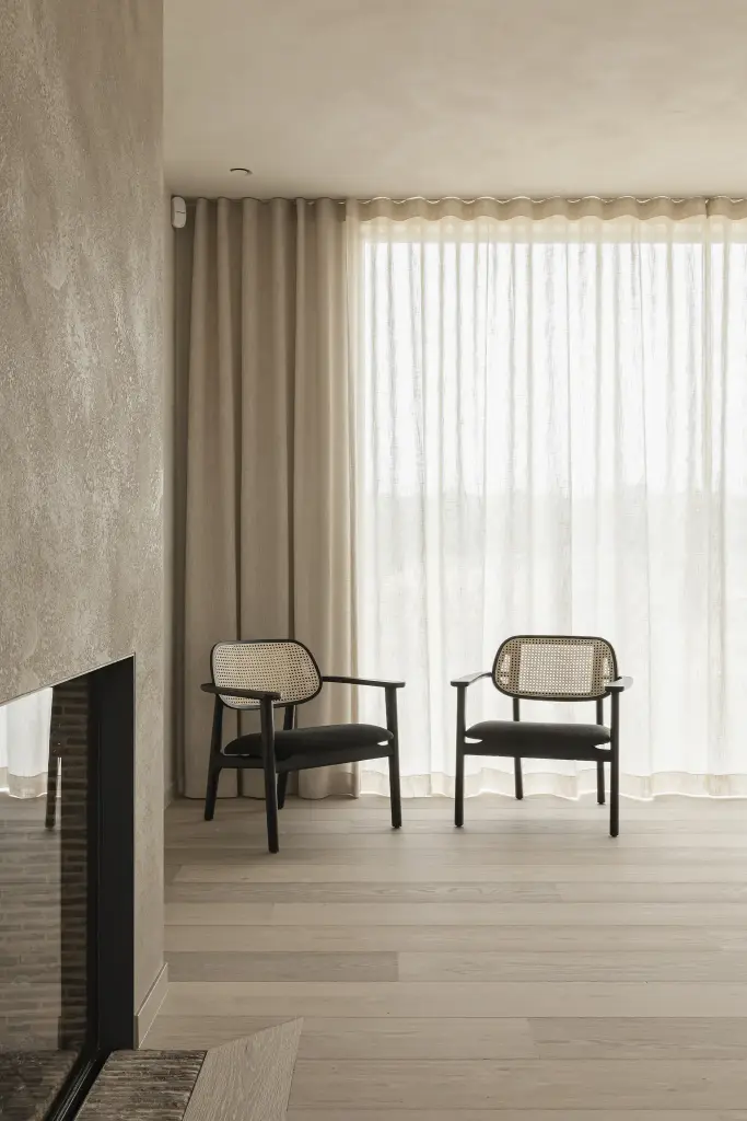 Zithoek met twee rotan fauteuils op een verhoogd podium voor het raam, where architecture creates space for experience, interieur Laura Calleeuw