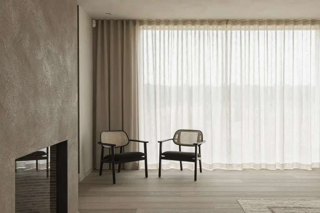 Zithoek met twee rotan fauteuils op een verhoogd podium voor het raam, where architecture creates space for experience, interieur Laura Calleeuw
