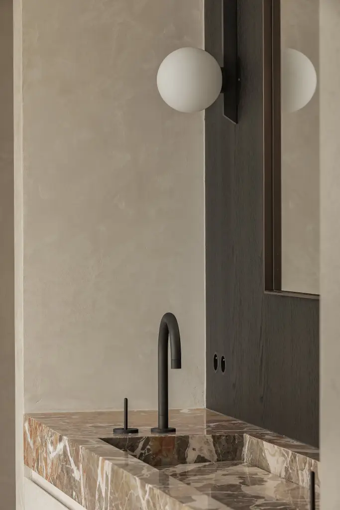 Badkamer met marmeren wastafel, bolvormige wandlamp en donker eiken paneel, Kijkwoning in Erpe-Mere, interieur Laura Calleeuw