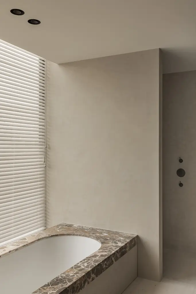 Badkamer met inbouwbad onder een raam met jaloezie, Kijkwoning in Erpe-Mere, interieur Laura Calleeuw