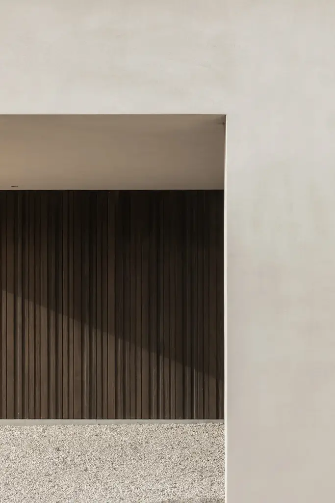 Overdekte ingang met houten wand en grindverharding, Kijkwoning in Erpe-Mere, interieur Laura Calleeuw