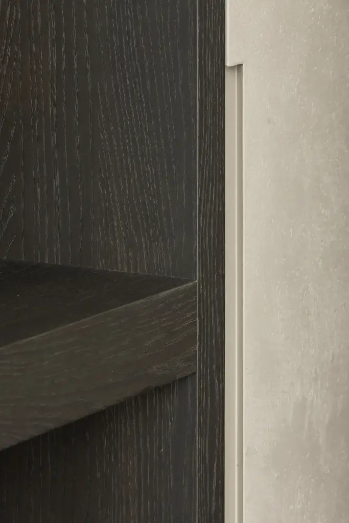 Detail van donker eikenhouten plank tegen een microcement wand, Kijkwoning in Erpe-Mere, interieur Laura Calleeuw