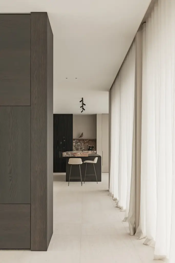 Doorkijk van de woonkamer naar de keuken met eiland en barkrukken, Kijkwoning in Erpe-Mere, interieur Laura Calleeuw