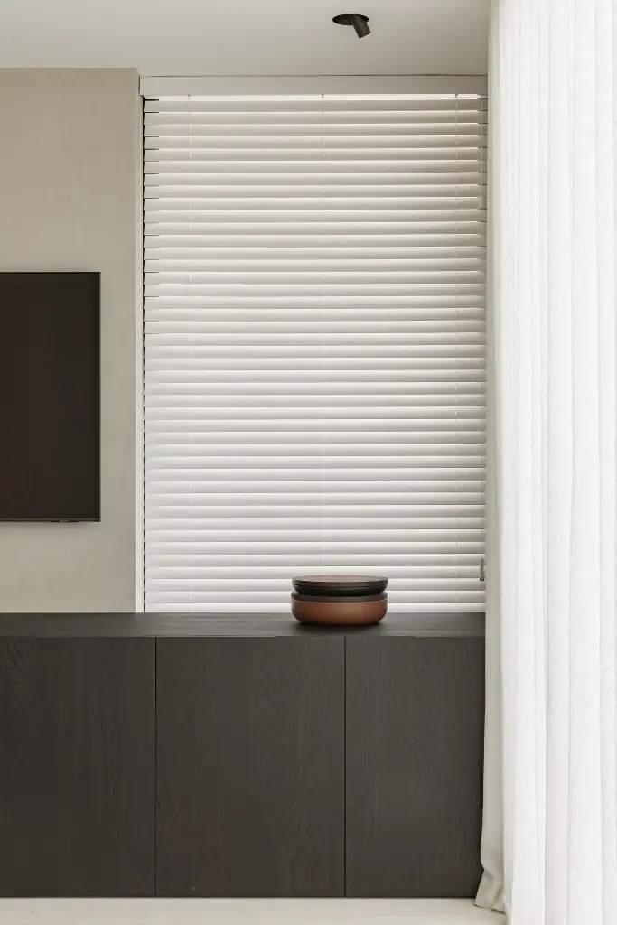 Dressoir in donker eiken met schaal voor een raam met jaloezie, Kijkwoning in Erpe-Mere, interieur Laura Calleeuw