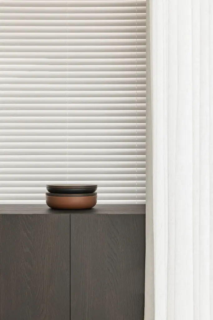 Dressoir in donker eiken met schaal voor een raam met jaloezie, Kijkwoning in Erpe-Mere, interieur Laura Calleeuw
