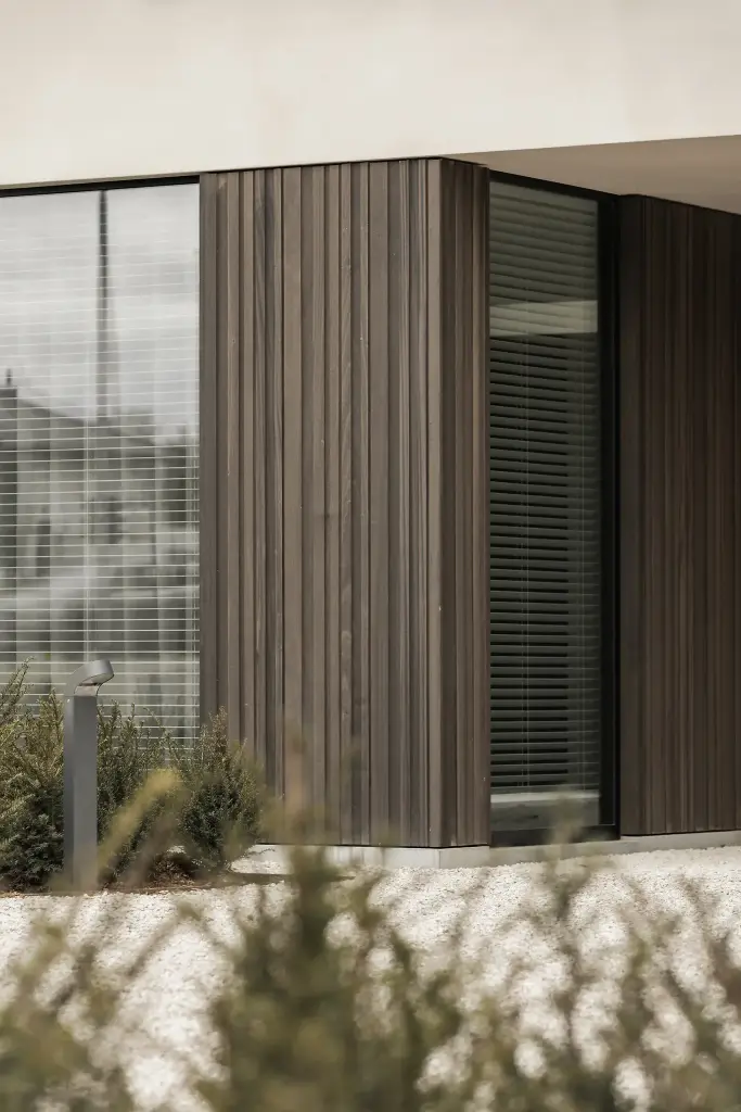 Detail van de gevel met verticale houten lamellen en een groot raam, Kijkwoning in Erpe-Mere, interieur Laura Calleeuw