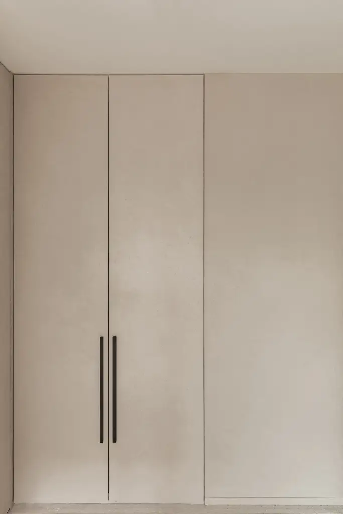 Inbouwkasten met lange zwarte grepen in microcement afwerking, Kijkwoning in Erpe-Mere, interieur Laura Calleeuw