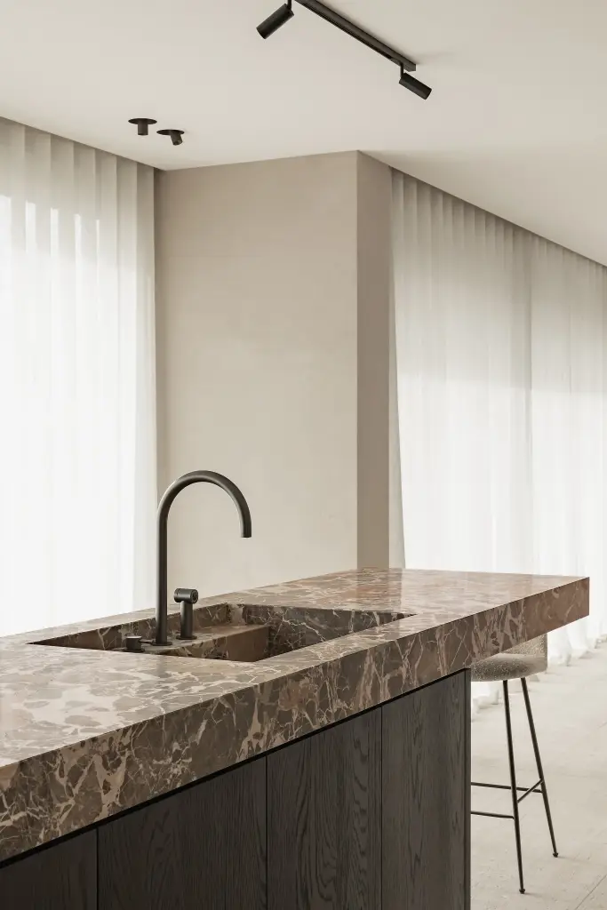 Keukeneiland met marmeren spoelbak en gebogen zwarte kraan, Kijkwoning in Erpe-Mere, interieur Laura Calleeuw