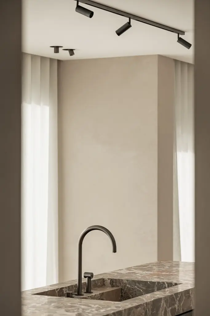 Keukeneiland met marmeren spoelbak en gebogen zwarte kraan, Kijkwoning in Erpe-Mere, interieur Laura Calleeuw