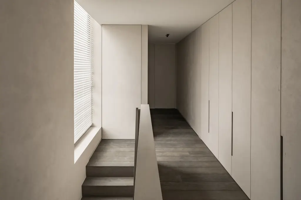Overloop met kastenwand, trapleuning en raam met jaloezie, Kijkwoning in Erpe-Mere, interieur Laura Calleeuw