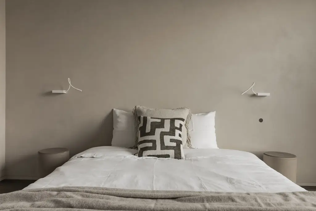 Slaapkamer met bed, leeslampjes en grafisch sierkussen, Kijkwoning in Erpe-Mere, interieur Laura Calleeuw