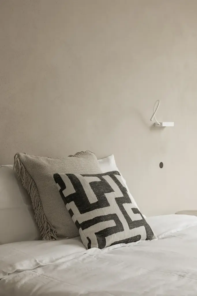 Slaapkamer met bed, leeslampjes en grafisch sierkussen, Kijkwoning in Erpe-Mere, interieur Laura Calleeuw