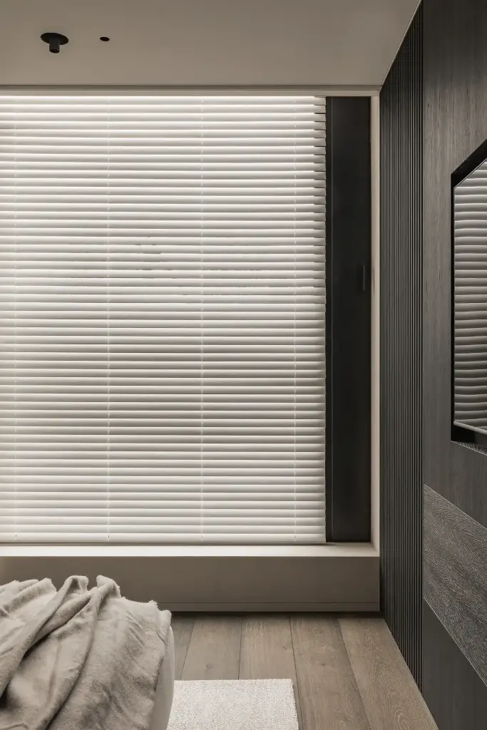 Slaapkamer met raam met jaloezie en donkere lamellenwand, Kijkwoning in Erpe-Mere, interieur Laura Calleeuw