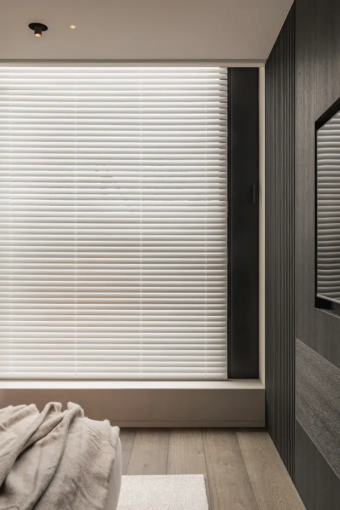 Slaapkamer met raam met jaloezie en donkere lamellenwand, Kijkwoning in Erpe-Mere, interieur Laura Calleeuw
