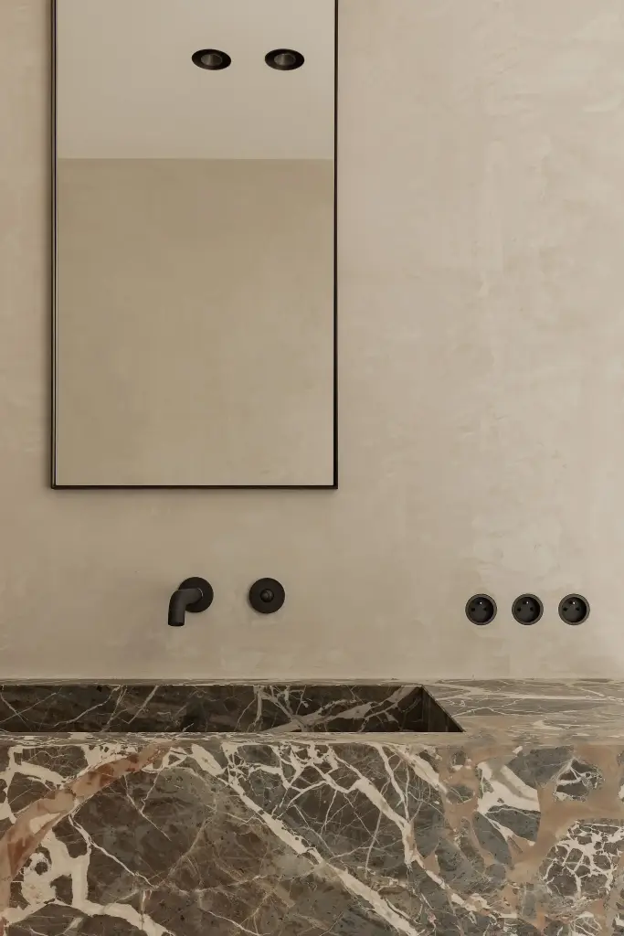 Marmeren wastafel met zwarte wandkranen en spiegel, Kijkwoning in Erpe-Mere, interieur Laura Calleeuw