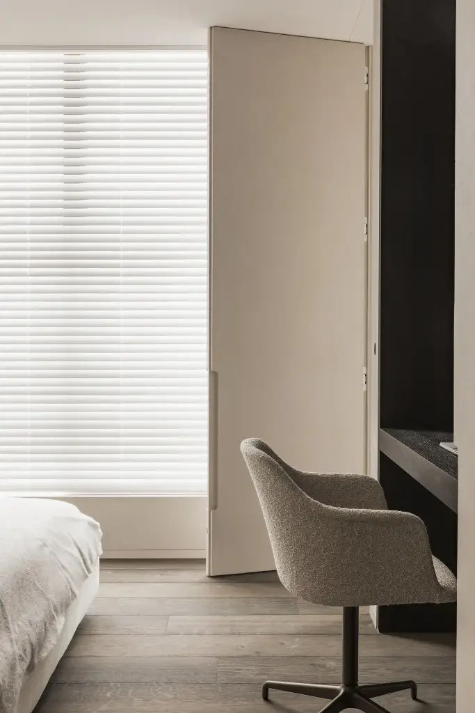 Slaapkamer met werkplek, bureaustoel en jaloezie voor het raam, Kijkwoning in Erpe-Mere, interieur Laura Calleeuw