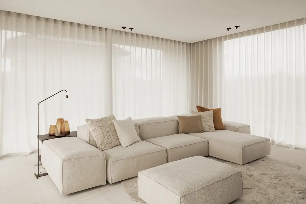 Woonkamer met crème hoekzetel en gordijnen met golfplooi, Kijkwoning in Erpe-Mere, interieur Laura Calleeuw