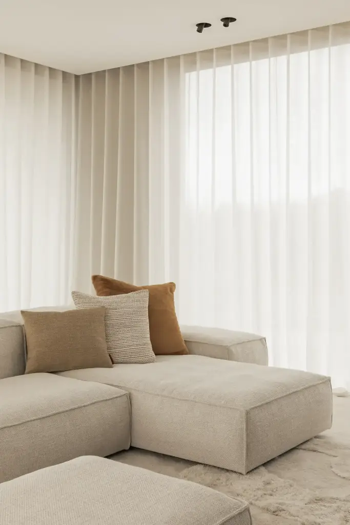 Woonkamer met crème hoekzetel en gordijnen met golfplooi, Kijkwoning in Erpe-Mere, interieur Laura Calleeuw