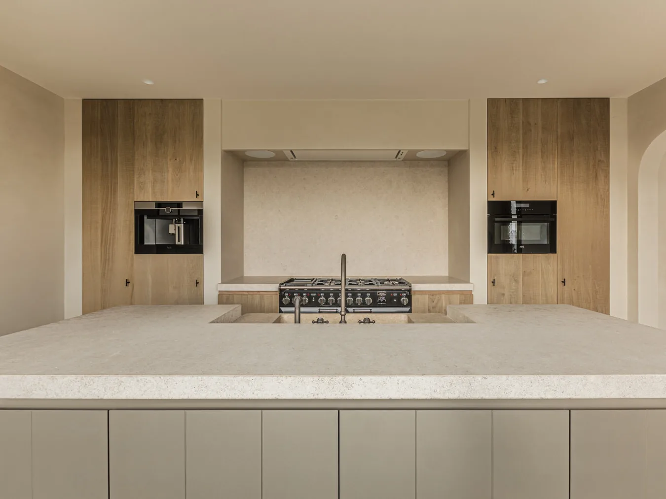 Keuken met kookeiland, fornuis in een nis, inbouwtoestellen en eikenhouten kolommen, Landelijke woning in Torhout, interieur Laura Calleeuw