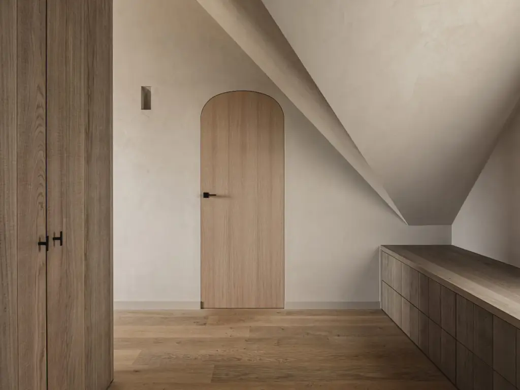 Eikenhouten kasten en een boogdeur in de kamer onder de dakhelling, met ladekast onder de schuine wand, Landelijke woning in Torhout, interieur Laura Calleeuw