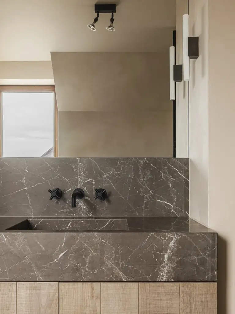 Wastafel in natuursteen met wandkranen, spiegel, wandlampen en spots, Landelijke woning in Torhout, interieur Laura Calleeuw