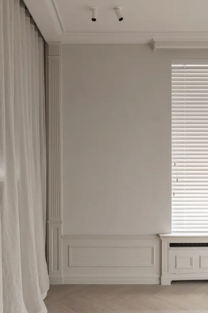 Wand met raam met jaloezie, plafondspots en een gordijn in de eetkamer, Herenhuis in Roeselare, interieur Laura Calleeuw