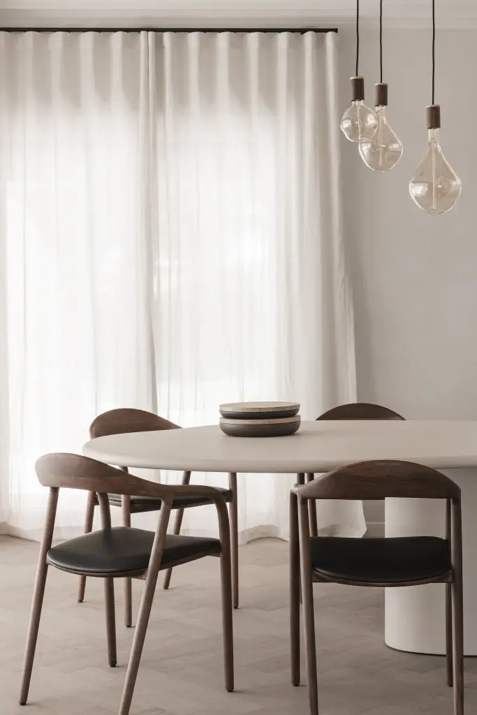 Eettafel met houten stoelen voor vitrage en hanglampen met grote gloeilampen, Herenhuis in Roeselare, interieur Laura Calleeuw