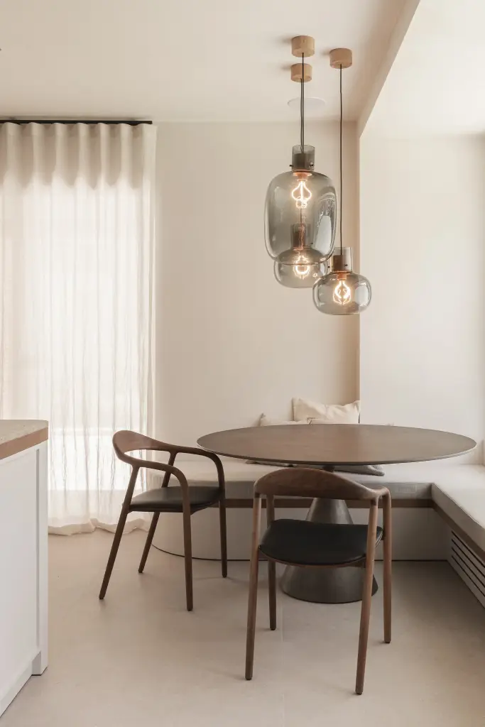 Grijze glazen hanglampen met zichtbare gloeilamp boven de ontbijthoek, Herenhuis in Roeselare, interieur Laura Calleeuw