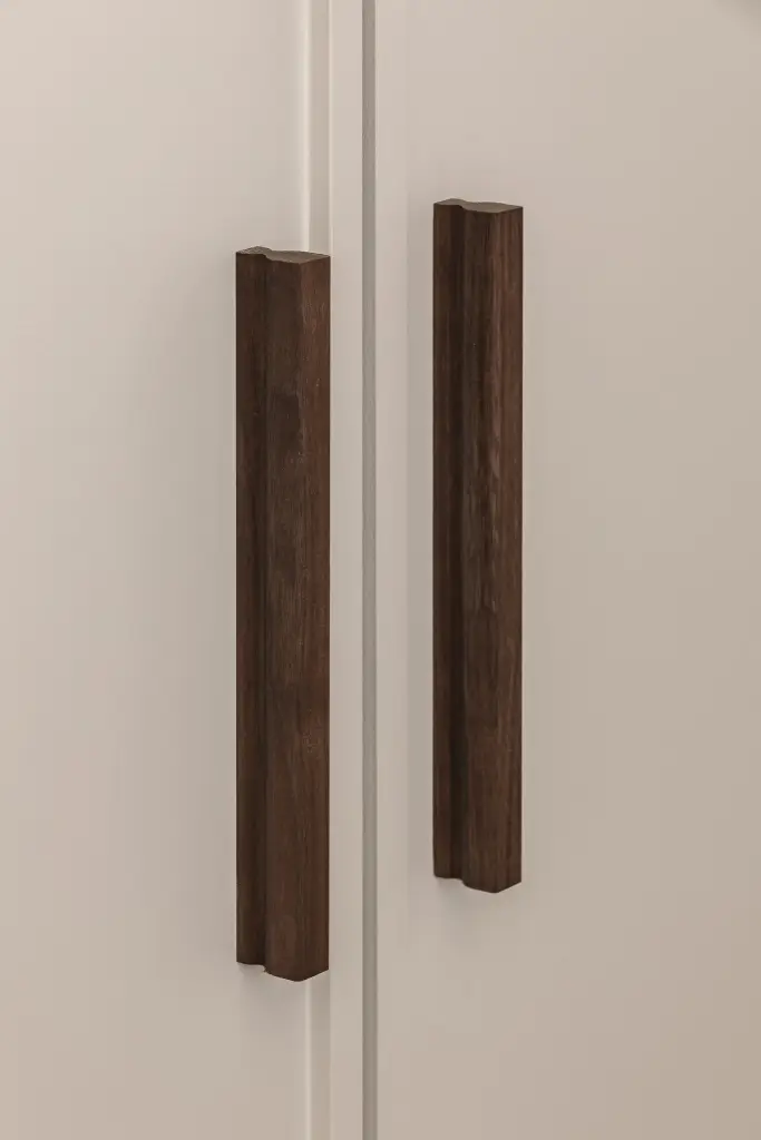 Twee verticale notelaren grepen op een wit kastfront, Herenhuis in Roeselare, interieur Laura Calleeuw