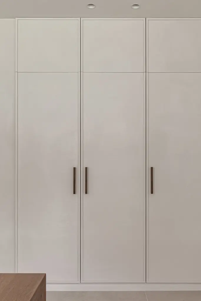Witte kastenwand met ingelijste deuren en houten grepen, Herenhuis in Roeselare, interieur Laura Calleeuw