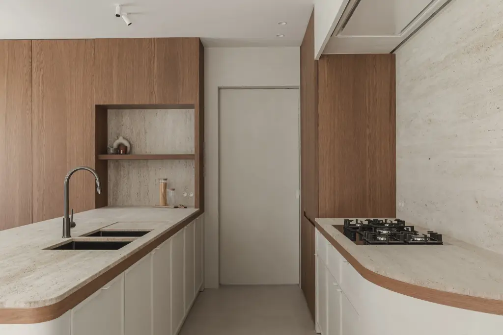 Keuken met dubbele spoelbak, gasfornuis en afgerond travertijnen blad met eikenhouten rand, Herenhuis in Roeselare, interieur Laura Calleeuw