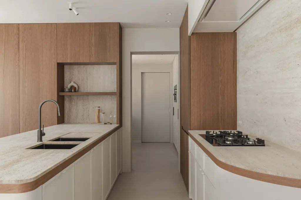 Keuken met dubbele spoelbak, gasfornuis en afgerond travertijnen blad met eikenhouten rand, Herenhuis in Roeselare, interieur Laura Calleeuw