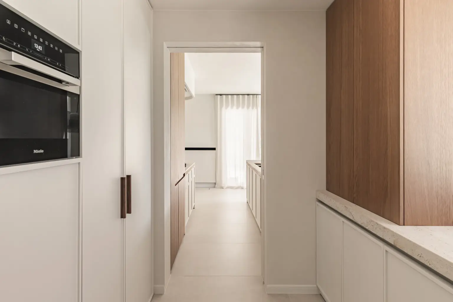 Keukenkolom met inbouwoven en een lange doorkijk door de gang, Herenhuis in Roeselare, interieur Laura Calleeuw