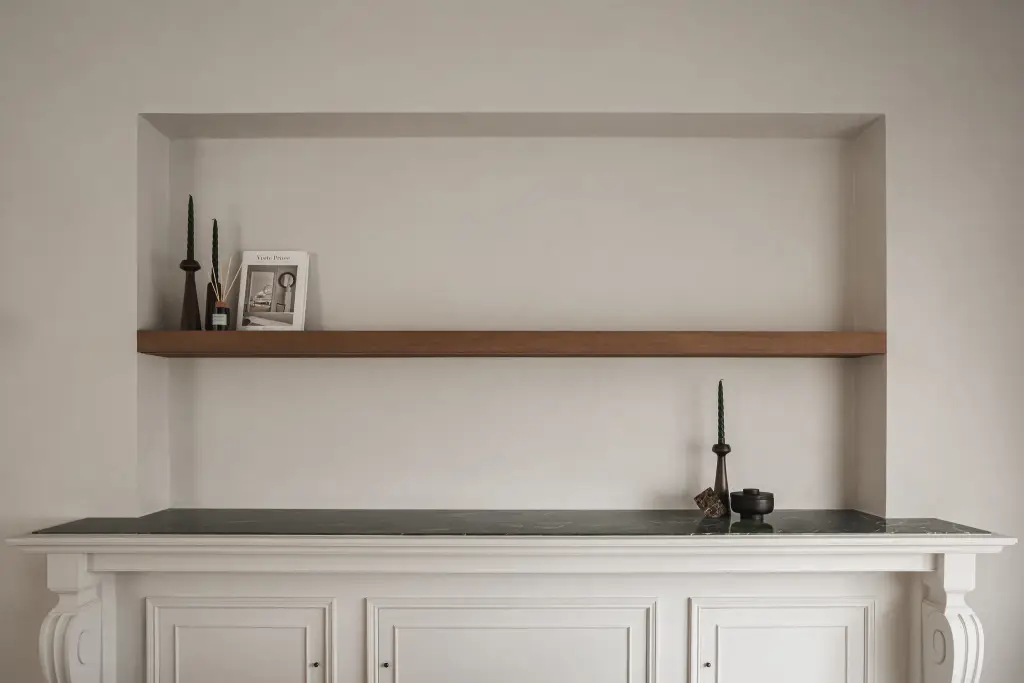 Nis met eikenhouten plank en sculpturen boven een klassiek wit dressoir, Herenhuis in Roeselare, interieur Laura Calleeuw