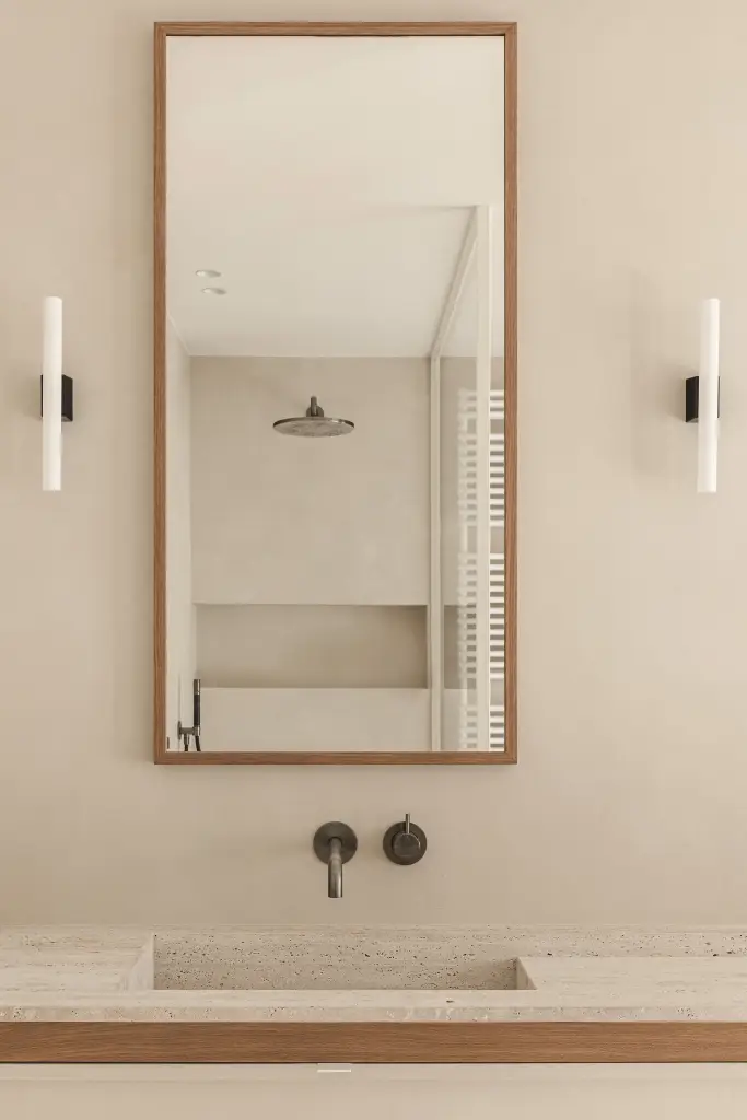 Hoge spiegel in eiken lijst met wandlampen boven de wastafel, met de douche weerspiegeld, Herenhuis in Roeselare, interieur Laura Calleeuw