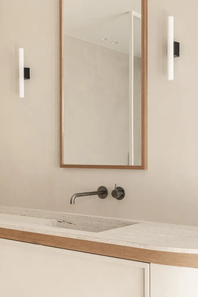 Wandkraan boven een natuurstenen wastafel met spiegel en wandlamp, Herenhuis in Roeselare, interieur Laura Calleeuw