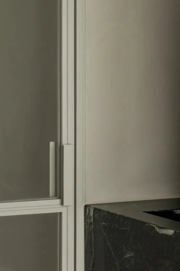 Badkamer achter glazen deur met zwart staalprofiel, Compact appartement in Knokke, interieur Laura Calleeuw