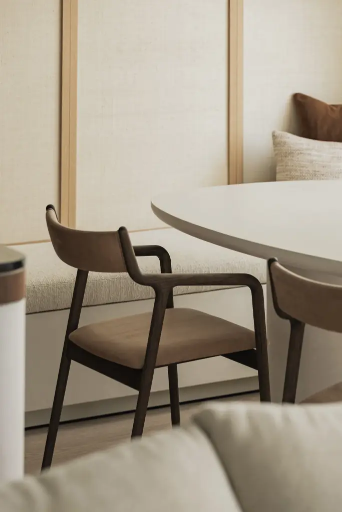 Ovale eettafel met leren stoel met houten armleuningen, Compact appartement in Knokke, interieur Laura Calleeuw