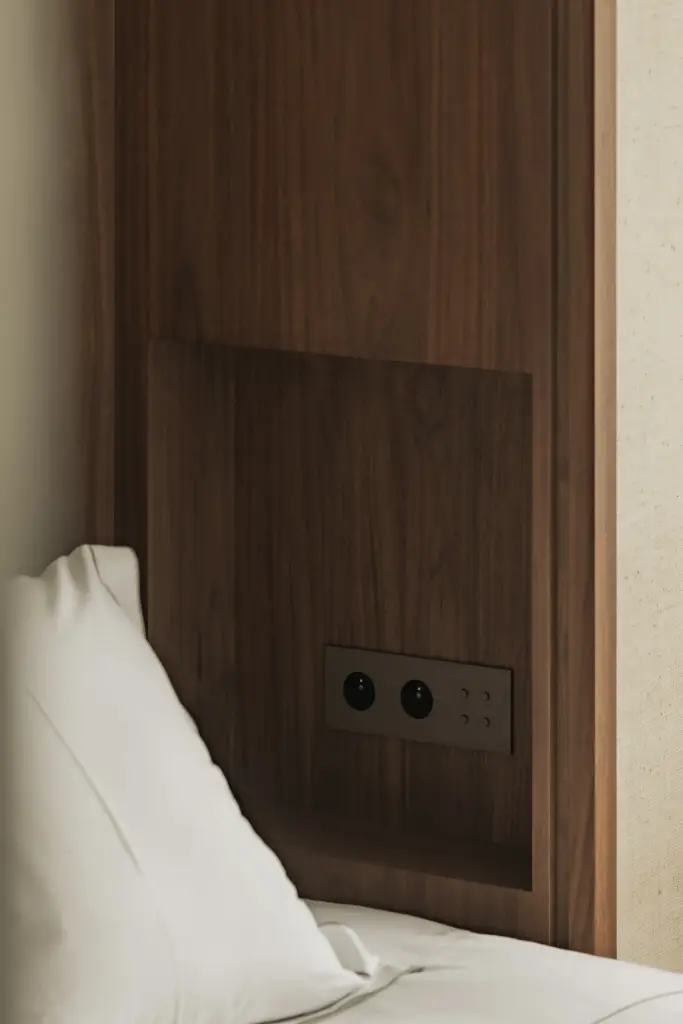 Walnoten wandpaneel met inbouwstopcontacten naast het bed, Compact appartement in Knokke, interieur Laura Calleeuw