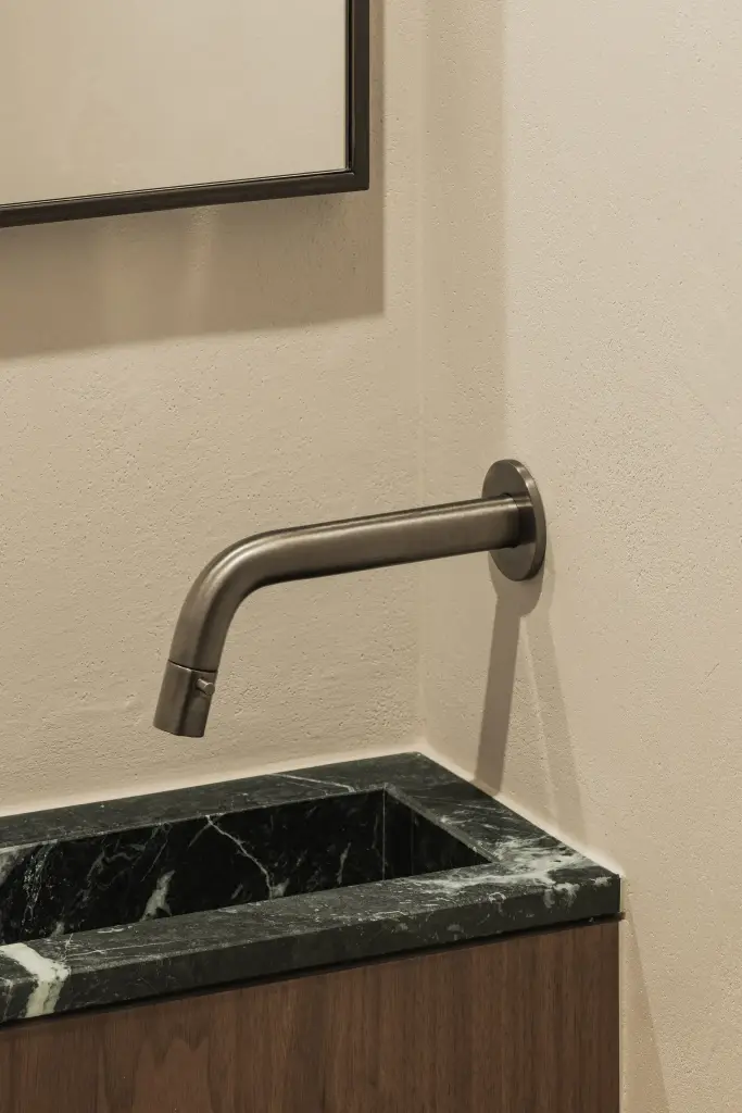 Toilet met wandfonteintje in groen marmer en walnoten onderkast, Compact appartement in Knokke, interieur Laura Calleeuw