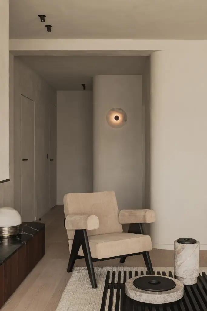 Woonkamer met open haard, bouclé zetel en fauteuil in zwart hout, Compact appartement in Knokke, interieur Laura Calleeuw