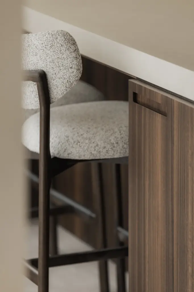 Detail van een bouclé barkruk aan het keukeneiland, Nieuwbouwwoning in Roeselare, interieur Laura Calleeuw