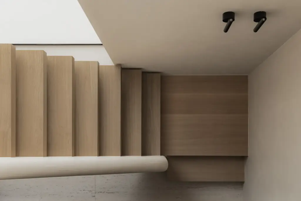 Eikenhouten trap met afgeronde gestucte leuning en zwarte spots, Nieuwbouwwoning in Roeselare, interieur Laura Calleeuw